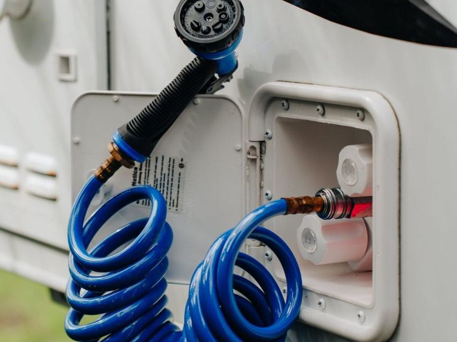 Exterior water inlet with a coiled blue hose